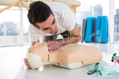Paramedic practicing resuscitation on dummy