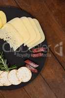 Cheese, rosemary, sausages and biscuit on slate board