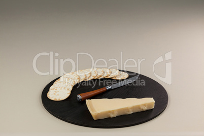Cheese with biscuits on chopping board