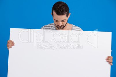 Handsome man holding a blank placard