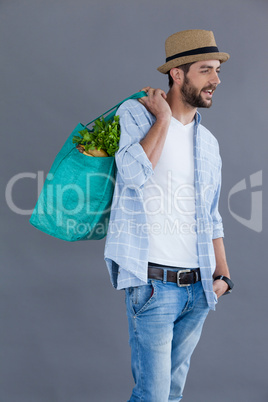 Man in fedora hat holding grocery bag