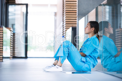 Depressed nurse sitting on floor