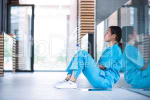 Depressed nurse sitting on floor
