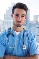 Portrait of handsome surgeon standing with arms crossed