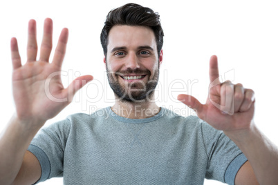 Smiling man pretending to touch an invisible screen