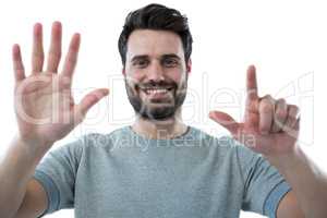Smiling man pretending to touch an invisible screen