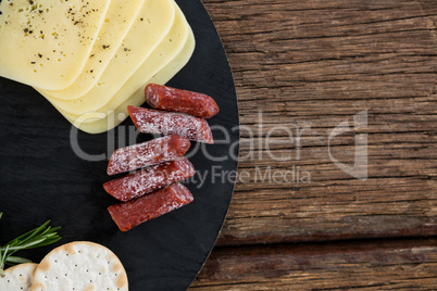 Slices of cheese, rosemary and nacho chips on plate