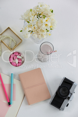 Flowers, diary, camera, glass and pearl necklace