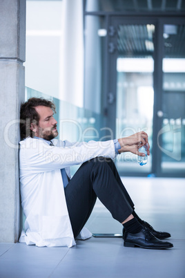 Worried doctor sitting on floor