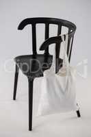 White bag hanging on a black chair