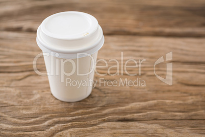 Disposable coffee cup on wooden background