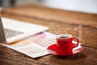 Red coffee cup on wooden table