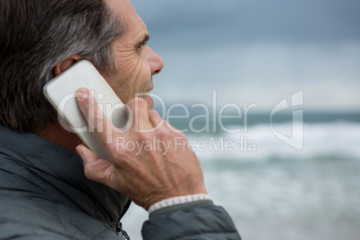 Man talking on mobile phone on beach