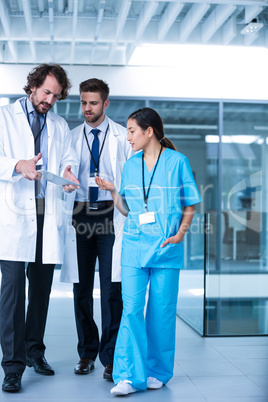 Doctor holding digital tablet having a discussion with colleagues