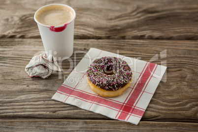 Doughnut and coffee on wooden plank