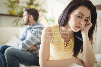 Upset couple ignoring each other on sofa