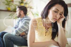 Upset couple ignoring each other on sofa