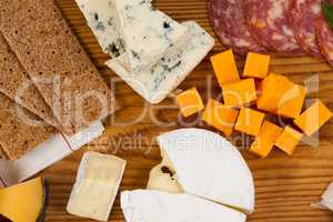 Variety of cheese with biscuits on chopping board