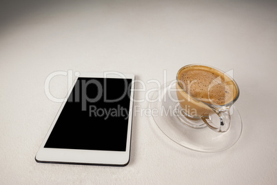 Digital tablet and cup of coffee