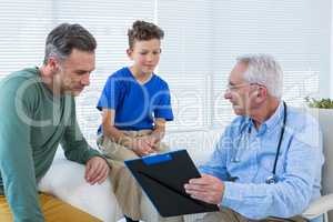 Doctor discussing reports with patient and his guardian