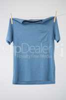Blue t-shirt with pocket hanging on clothes line