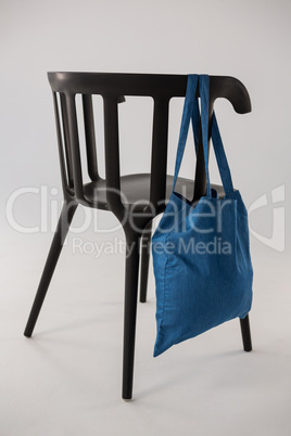 Blue bag hanging on a black chair