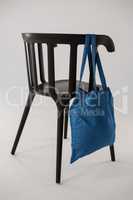 Blue bag hanging on a black chair