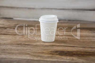 Disposable coffee cup on wooden table