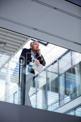 Businessman holding digital tablet at office corridor