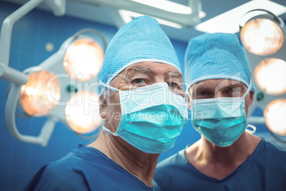 Portrait of male surgeons wearing surgical mask in operation theater