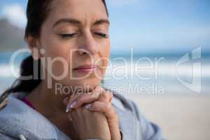 Mature woman praying with hands clasped