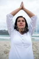 Woman performing yoga on beach