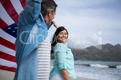 Couple holding american flag on beach