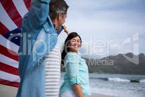 Couple holding american flag on beach