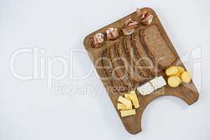 Variety of cheese with brown bread on wooden board