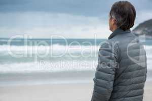 Thoughtful man standing on beach