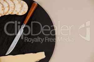 Slice of cheese with crispy biscuits and knife