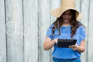 Woman in blue top and hat using digital tablet