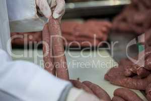 Butcher processing sausages