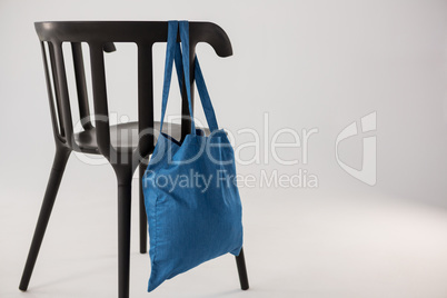 Blue bag hanging on a black chair