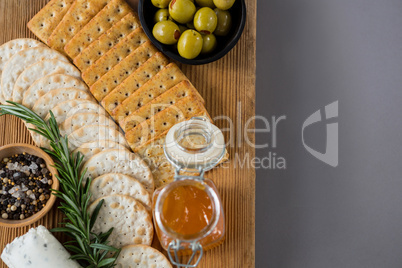 Variety of cheese with olives, honey, rosemary, walnuts and crackers