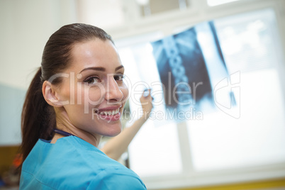Portrait of female nurse examining x-ray report