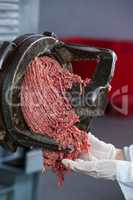 Minced meat coming out from grinder