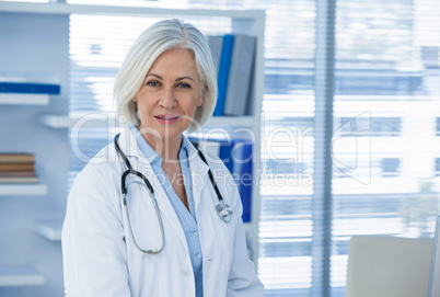 Portrait of a smiling female doctor sitting at desk