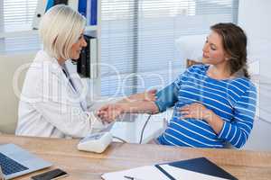 Female doctor checking blood pressure of a patient