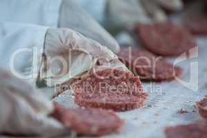 Butchers processing hamburger patty
