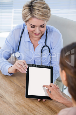 Doctor and patient discussing over digital tablet