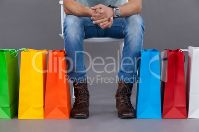 Man sitting on a chair with colorful shopping bags