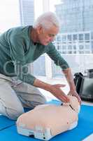 Paramedic practicing resuscitation on dummy