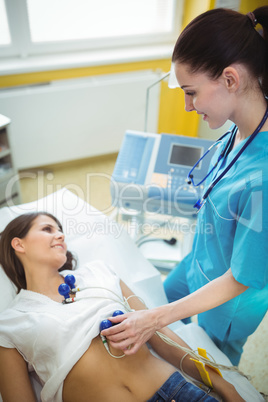 Nurse performing an electrocardiogram test on the patient